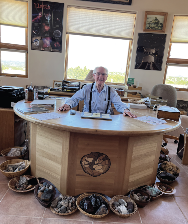 Richard Blake smiles at the camera while sitting amongst his collection