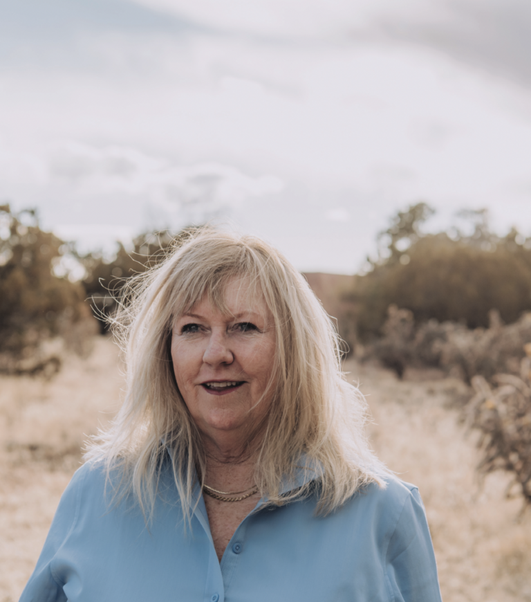 Sally Denton stands in the New Mexico brushlands